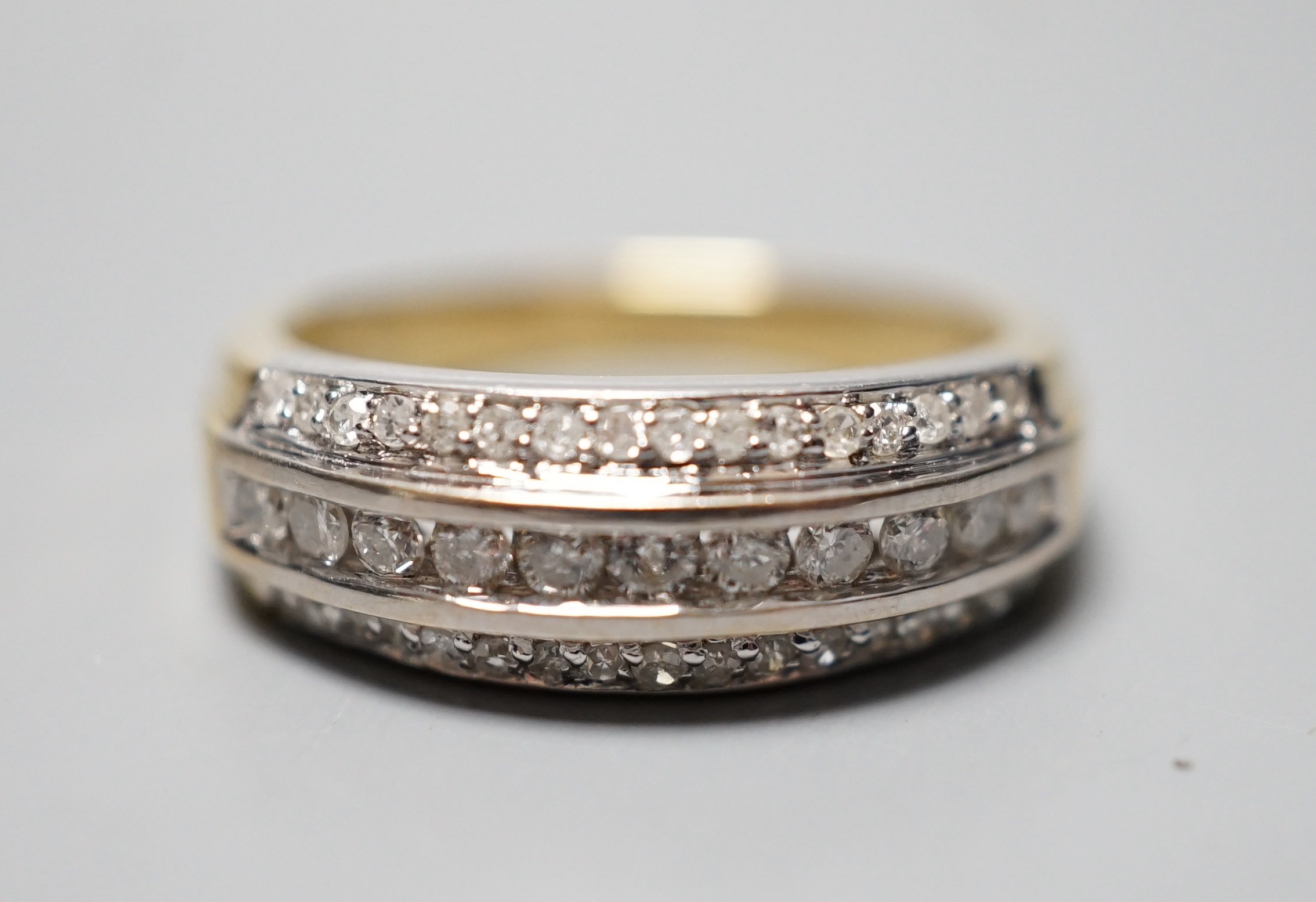 A modern 18ct gold and three row diamond set half eternity ring, size P, gross weight 6.8 grams.